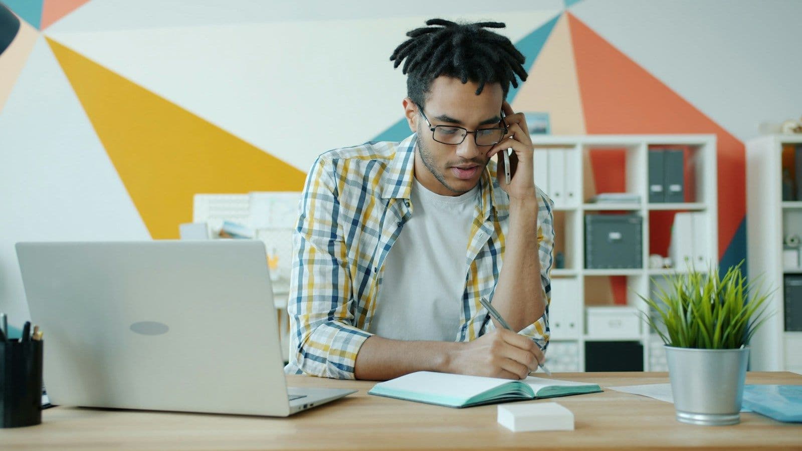 A forwarder on the phone at his desk, a notebook open in front of him.